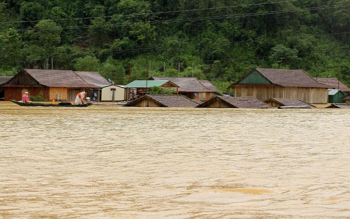 This picture taken on October 8, 2020 and released on October 9, 2020 by the Vietnam News Agency shows houses inundated by floodwaters following heavy rainfall in Central Vietnam's Quang Binh province. 