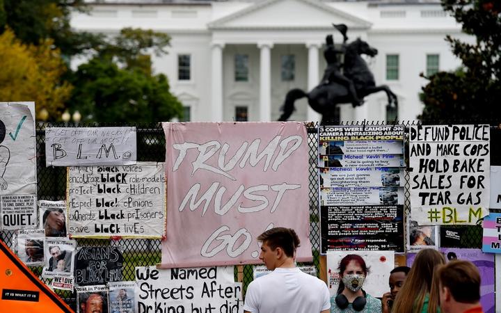 People stand at Black Lives Matter Plaza in Washington, DC, on October 10, 2020, ahead of a speech by US President Donald Trump at the White House.