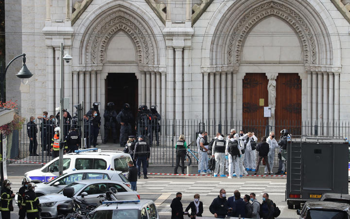 French members of the elite tactical police unit RAID enter to search the Basilica of Notre-Dame de Nice as forensics officers wait after a knife attack in Nice on October 29, 2020.