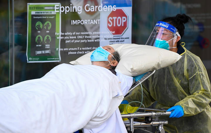 Ambulance officers transfer a resident from the Epping Gardens aged care facility in the Melbourne suburb of Epping on 28 July 2020.