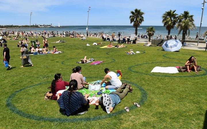 People enjoy the warm weather on Melbourne's St Kilda Beach on November 3, 2020, as Australia's Victoria state records its fourth straight day of zero transmissions of the COVID-19 coronavirus 