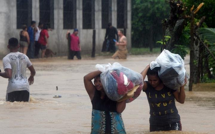 Local residents save their belongings at the Alemania suburb, due to the heavy rains caused by Hurricane Eta, in the city of El Progreso, department of Yoro, 260 kms north of Tegucigalpa, on November 4, 2020. -