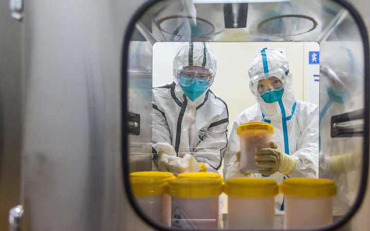 Staff members receive the novel coronavirus strain transported to a laboratory of Chinese Center for Disease Control and Prevention, in Beijing, on February 25, 2020. 