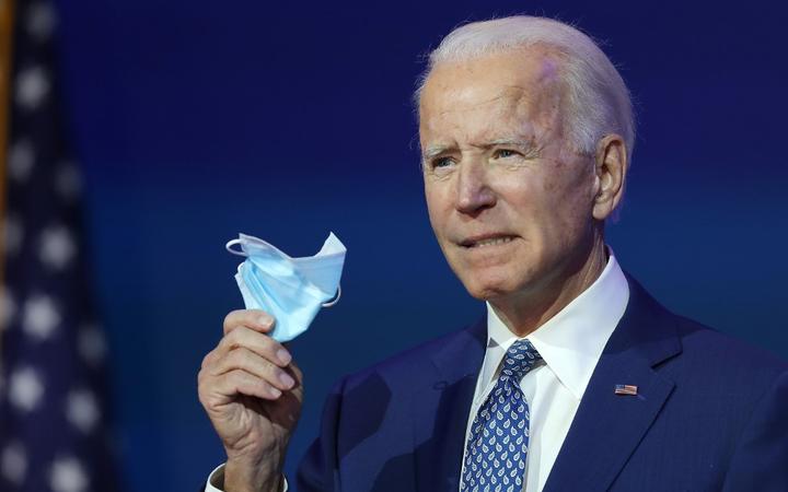 WILMINGTON, DELAWARE - NOVEMBER 09: U.S. President-elect Joe Biden holds a protective mask as he speaks to the media after receiving a briefing from the transition COVID-19 advisory board on November 09, 2020 at the Queen Theater in Wilmington, Delaware. 