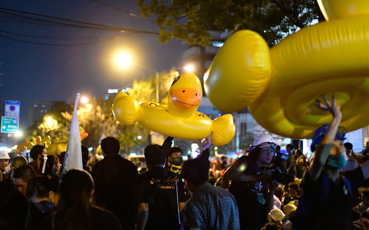 Pro-democracy protesters move inflatable rubber ducks during an anti-government rally outside the Royal Thai Police Headquarters.