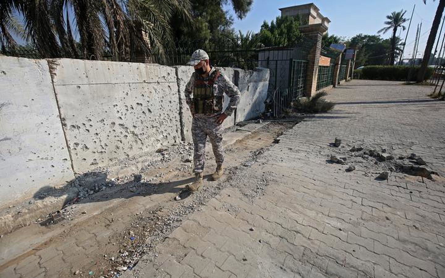 A member of the Iraqi security forces inspects the damage outside the Zawraa park in Baghdad on November 18, 2020, after rockets slammed into the Iraqi capital. 
