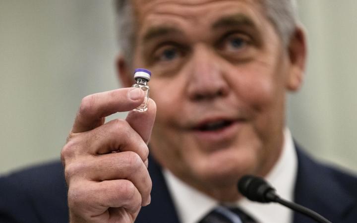 Wesley Wheeler, President of Global Healthcare at United Parcel Service (UPS), holds up a sample of the vial that will be used to transport the Pfizer COVID-19 vaccine at a Senate hearing in Washington 