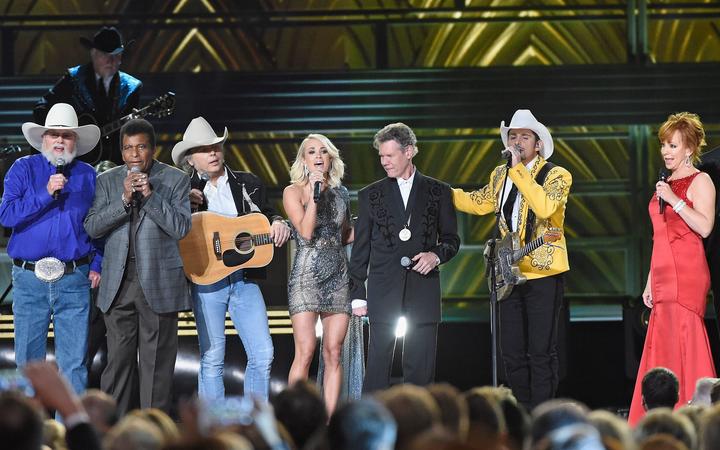 NASHVILLE, TN - NOVEMBER 02: (L-R) Charlie Daniels, Charley Pride, Dwight Yoakam, Carrie Underwood, Randy Travis, Brad Paisley, Reba McEntire, perform onstage at the 50th annual CMA Awards at the Bridgestone Arena on November 2, 2016 in Nashville, Tennessee. 