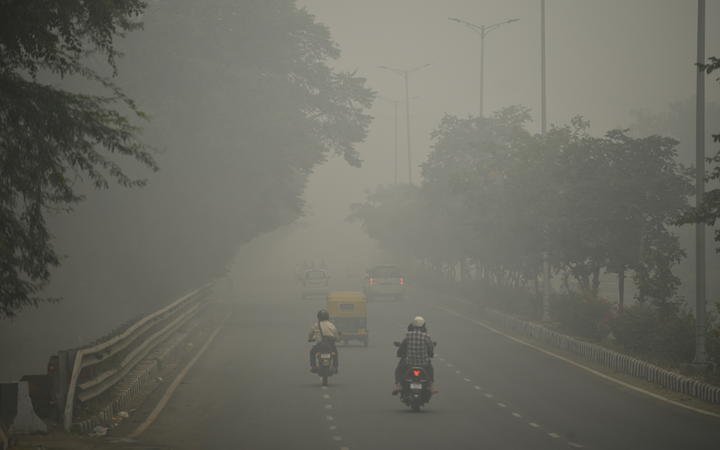Motorists drive along a road under heavy smog conditions, in New Delhi on 3 November, 2019.