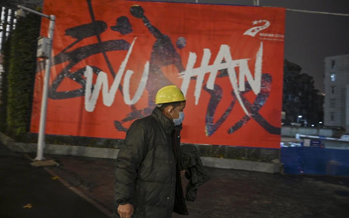 A man wearing a protective facemask walks along a street in Wuhan on 26 Januar, a city at the epicentre of a novel coronavirus outbreak.