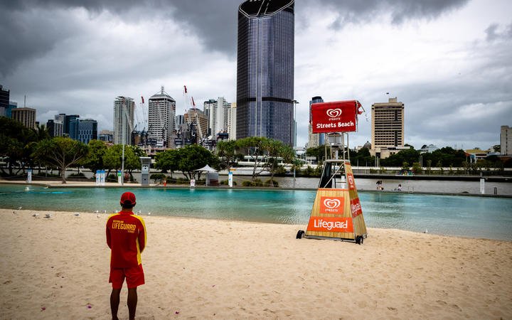 A lifeguard stands watch over a deserted South Bank beach on the first day of a snap lockdown in Brisbane on 9 January 