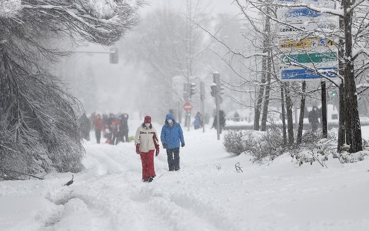 MADRID, SPAIN - JANUARY 09: People walk on snow covered road as they enjoy during heavy snowfall in Madrid, Spain on January 09, 2s021. 