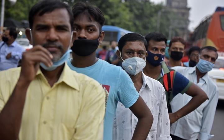 People stand on a line without maintaining social distancing amid coronavirus emergency in Kolkata, India, on 8 October, 2020. 