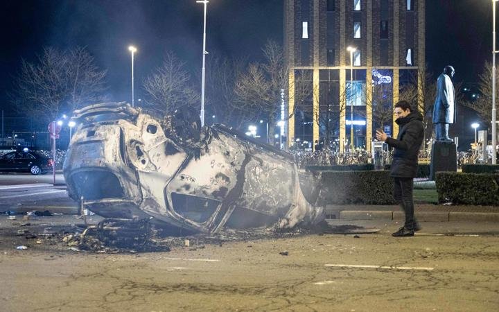 A burned car in front of Eindhoven central train station after the anti-lockdown protest.