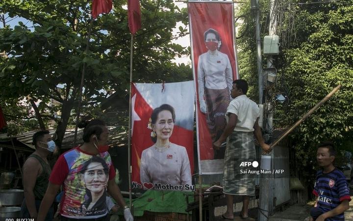Supporters of the National League for Democracy (NLD) party stand with banners of Myanmar state counsellor Aung San Suu Kyi ij November 2020.