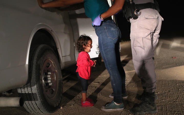 (FILES) In this file photo taken on June 11, 2018 a two-year-old Honduran asylum seeker cries as her mother is searched and detained near the U.S.-Mexico border in McAllen, Texas. 